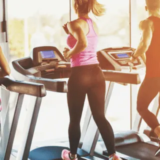 two women and two men on treadmills working out in gym