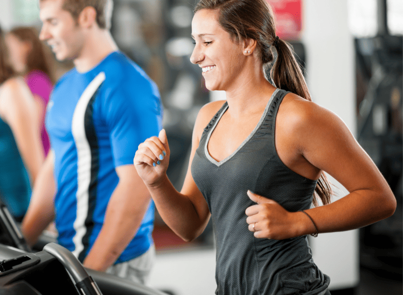 woman on treadmill smiling and working out