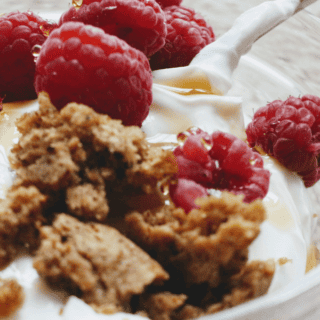 close up of plain yogurt with berries and granola