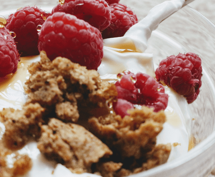 close up of plain yogurt with berries and granola