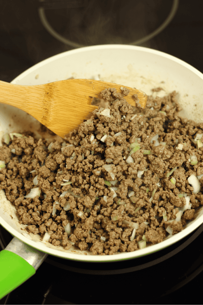 Ground beef, onions and garlic browning in a skillet.