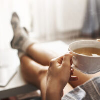 Cup,Of,Tea,And,Chill.,Woman,Lying,On,Couch,,Holding