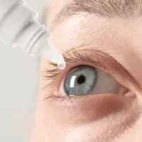 Woman,Applying,Eye,Drops,On,Light,Background,,Closeup